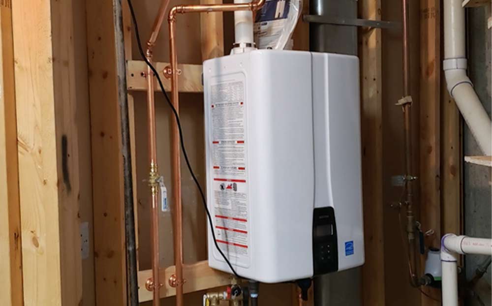 A tankless water heater installed to replace an older full tank water heater